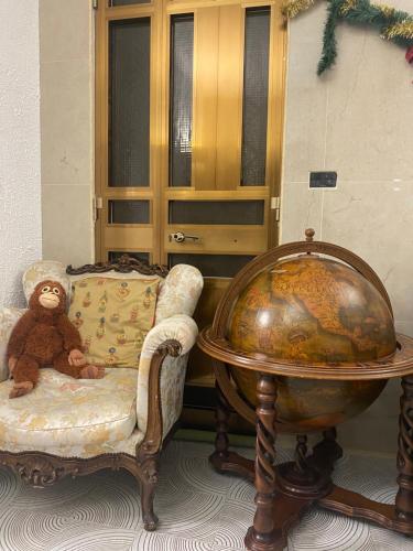 a teddy bear sitting on a chair next to a globe at Ferienhaus am Meer Süd Italien Torre Chianca in Torre Chianca