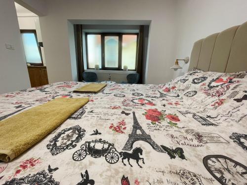 a bed with a blanket with the eiffel tower at Central Residence in Târgu Jiu