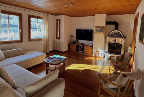 ein Wohnzimmer mit einem Sofa und einem Tisch in der Unterkunft Lussuoso Chalet in centro a 4 min a piedi dalle piste da sci in Tarvis