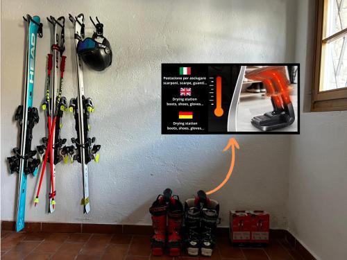 a wall with a bunch of skis hanging on a wall at Lussuoso Chalet in centro a 4 min a piedi dalle piste da sci in Tarvisio