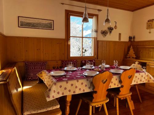 a dining room with a table and chairs and a window at Lussuoso Chalet in centro a 4 min a piedi dalle piste da sci in Tarvisio