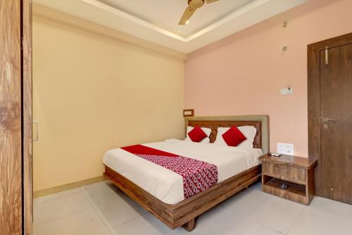 a bedroom with a bed with red pillows at Bhagirathi Residency in Anantapur