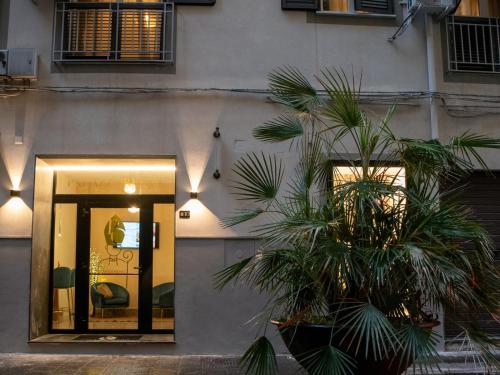 um edifício com palmeiras em frente a uma porta em PALAZZOREFICI em Nápoles