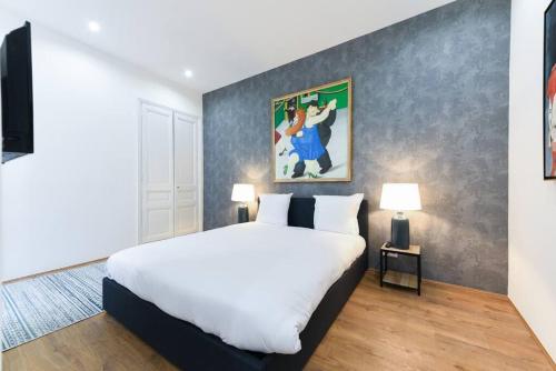 une chambre avec un lit blanc et un tableau au mur dans l'établissement 3 DAUMAS - Superbe appartement 2 chambres hyper centre Cannes, à Cannes