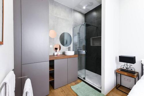 La salle de bains est pourvue d'une douche et d'une coiffeuse avec un miroir. dans l'établissement 3 DAUMAS - Superbe appartement 2 chambres hyper centre Cannes, à Cannes