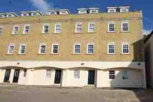 a large yellow building with a lot of windows at Elegant Central Brentwood Flat in Brentwood