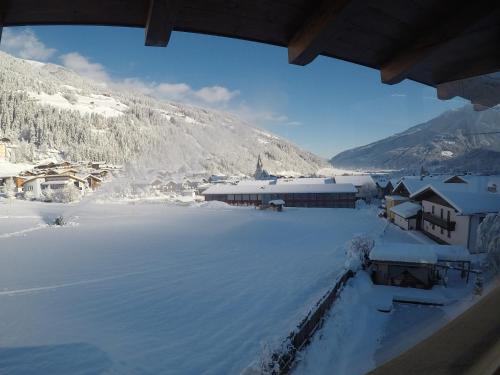 a view from a window of a snow covered village at Ferienhaus Bergauf with Hot Tub in Neukirchen am Großvenediger