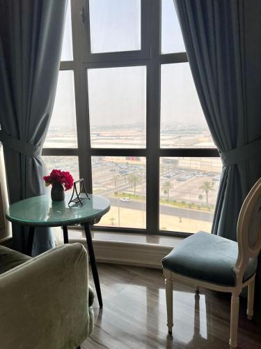 a living room with a table and a large window at Aswar Boutique Hotel in Al Khobar