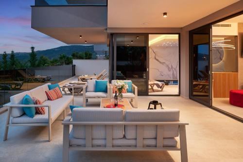 a patio with couches and a table and chairs at Villas Lucy - 1 Lemon -outdoor pool , 2 Cherry-indoor pool and 3 Plum-outdoor pool in Marina