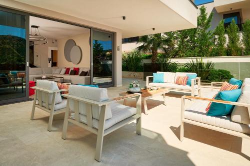 a patio with white chairs and a table at Villas Lucy - 1 Lemon -outdoor pool , 2 Cherry-indoor pool and 3 Plum-outdoor pool in Marina