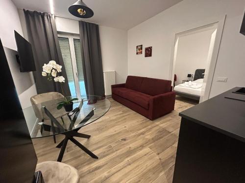 a living room with a red couch and a glass table at Apartment Teatro in Bolzano