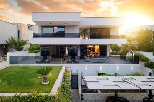 a house with a view of the backyard at Villas Lucy - 1 Lemon -outdoor pool , 2 Cherry-indoor pool and 3 Plum-outdoor pool in Marina