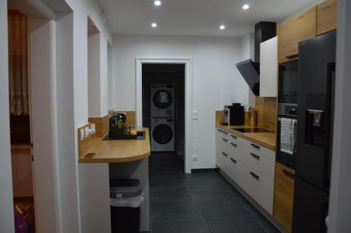 uma cozinha com máquina de lavar e secar roupa num quarto em Kinderlachen garantiert em Lutzmannsburg
