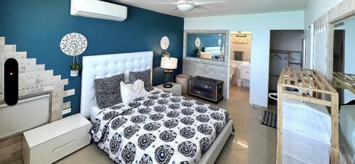 San Juan 1 BR Ocean Front Condo in Condado '8' في سان خوان: غرفة نوم بسرير وجدار ازرق