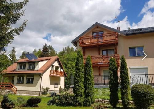 a large house with a balcony and trees at Zielony Zakątek Karpacz Apartamenty in Karpacz