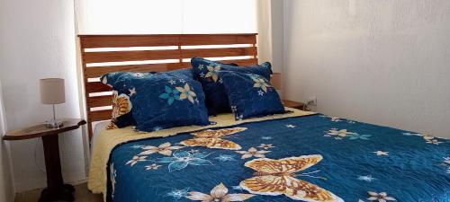 ein Bett mit einer blauen Decke mit Schmetterlingen drauf in der Unterkunft Casa Finca Lindora in Monteverde Costa Rica