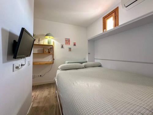 um quarto com uma cama e uma televisão de ecrã plano em Tu estudio en el centro de Madrid em Madrid