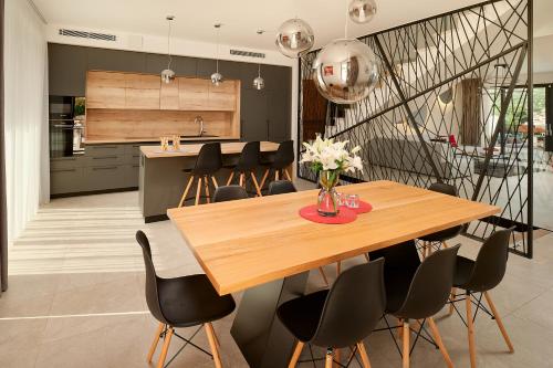 a kitchen and dining room with a wooden table and chairs at Villas Lucy - 1 Lemon -outdoor pool , 2 Cherry-indoor pool and 3 Plum-outdoor pool in Marina