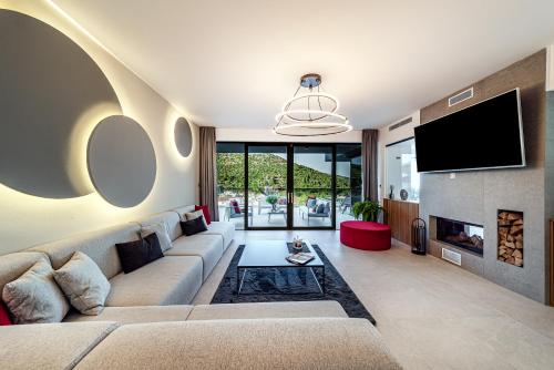 a living room with a couch and a tv at Villas Lucy - 1 Lemon -outdoor pool , 2 Cherry-indoor pool and 3 Plum-outdoor pool in Marina