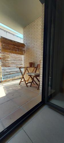 een patio met een houten tafel en een raam bij Apartamento Hort Adell in Les Cases d'Alcanar