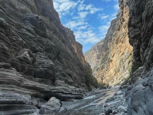 a canyon with a river in the middle of a mountain at Jabal Shams bayt kawakib in Misfāh