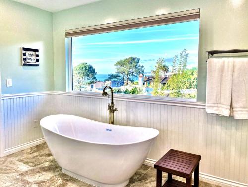 uma banheira branca na casa de banho com uma janela em Endless Vistas On The Cove Perfection - Spa, Pet-Friendly, Stunning Views, Large Parking & AC em San Diego