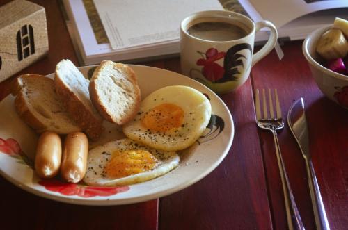 einen Teller Eier und Toast und eine Tasse Kaffee in der Unterkunft House Of Jars in Vientiane