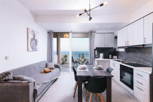 a kitchen and living room with a table and a couch at Stella Apartment in Kali Limenes
