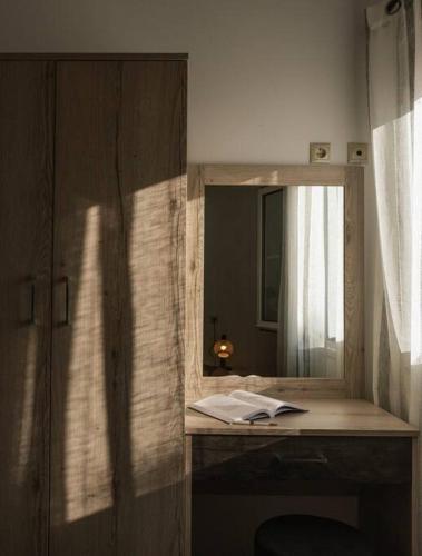 a desk with a mirror and a book on it at Stella Apartment in Kaloi Limenes