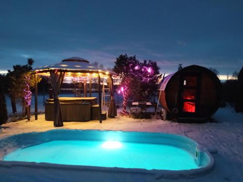 a hot tub in the snow next to a yurt at Dom na Mazurach WrzoSPA in Stare Juchy