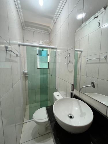 a bathroom with a sink and a toilet and a shower at Pousada Elegance Beira Mar in Itanhaém