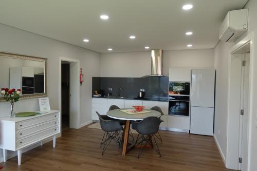 a kitchen with a table and chairs in a room at Montinho 313 in Arouca
