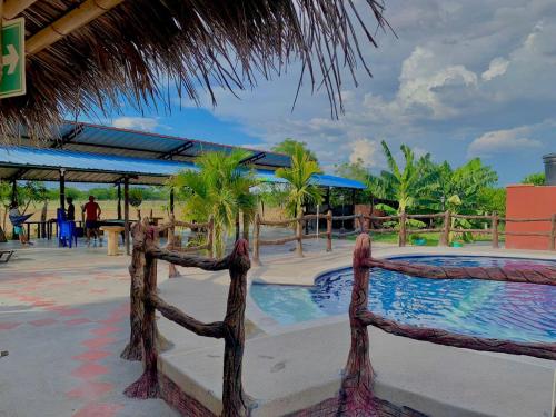 a resort with a swimming pool and palm trees at Hotel campestre la isla in Neiva