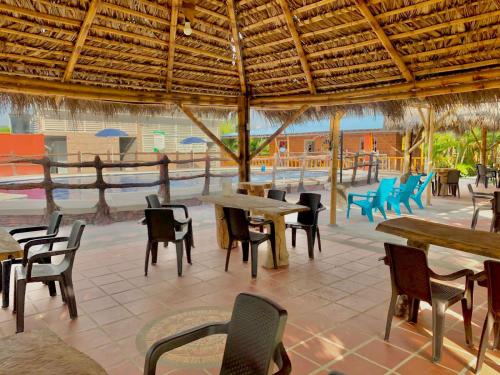 a restaurant with tables and chairs and a view of the water at Hotel campestre la isla in Neiva