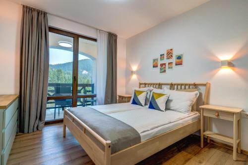 a bedroom with a bed and a balcony at N.Joy Holiday Apartment 534 by Oak Residence in Smolyan