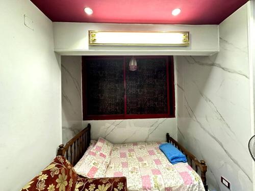 Habitación pequeña con cama y ventana en Sanctuary, en El Cairo