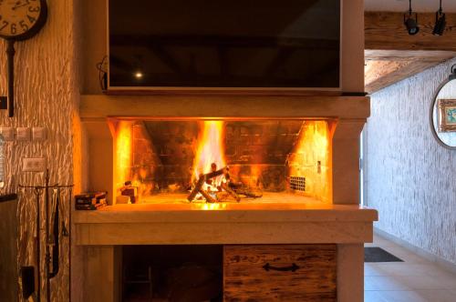 a stone fireplace with a fire in it at Villas Lucy - 1 Lemon -outdoor pool , 2 Cherry-indoor pool and 3 Plum-outdoor pool in Marina