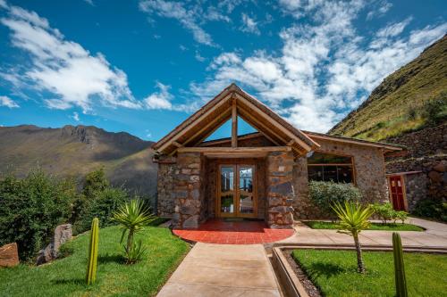 a stone house with mountains in the background at Stardome Spiritual Experience in Ollantaytambo
