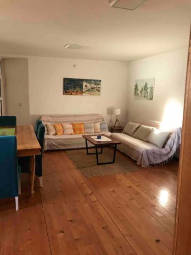 a living room with two beds and a table at Garden's apartman - Kosjerić in Kosjerić