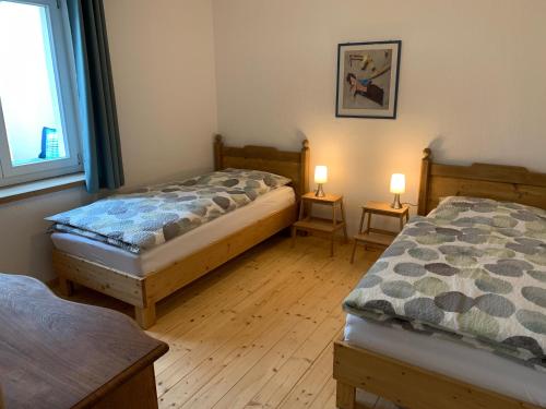 two beds in a room with two lamps on tables at Voigtshof Niederrhein Ferienwohnung „Balberg“ in Sonsbeck