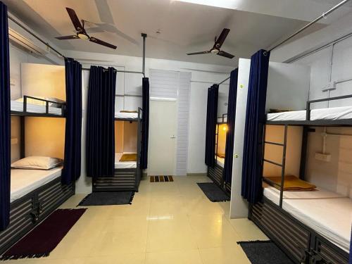 Zimmer mit 4 Etagenbetten und blauen Vorhängen in der Unterkunft Marhaba family dormitory in Kozhikode