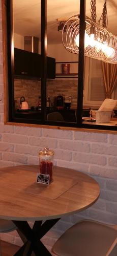 a wooden table with a candle on top of it at Gîtes déco pop et chaleureuse avec jacuzzi, sauna, piece coquine in Calais