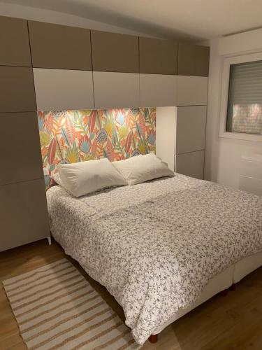 1 dormitorio con 1 cama grande y cabecero de flores en L’Abri Cotier - Appartement face mer 2/4 personnes, en Fort-Mahon-Plage