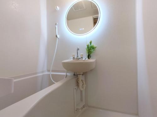 W białej łazience znajduje się umywalka i lustro. w obiekcie S13-Shibuya center 7 mins to Station, Max 4P涉谷最中心 涉谷站7分 w Tokio