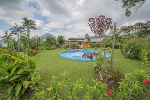 a garden with a swimming pool in a yard at Essence Arenal Spa & Yoga in El Castillo de La Fortuna