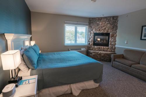 a bedroom with a bed and a couch and a fireplace at Weathervane Inn in Montague