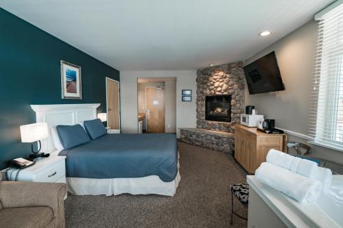 a bedroom with a blue bed and a fireplace at Weathervane Inn in Montague