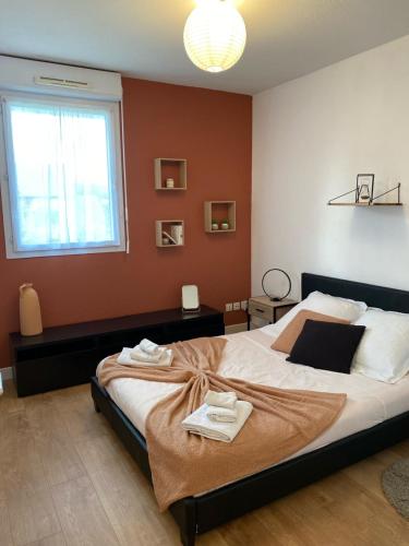 a bedroom with a large bed with towels on it at Honfleur: calme & piscine privée in La Rivière-Saint-Sauveur