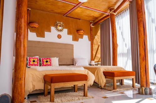 a bedroom with a bed and two benches in it at Stardome Spiritual Experience in Ollantaytambo