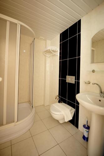 a white bathroom with a toilet and a sink at Önder Yıldız Hotel in Kızılot